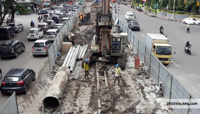 Alat berat dan pipa yang melebihi ukuran manusia