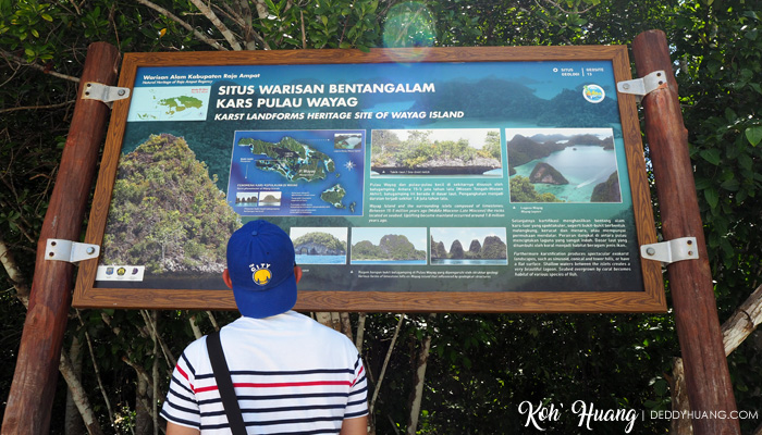 Andre serius melihat infografis di Pulau Wayag