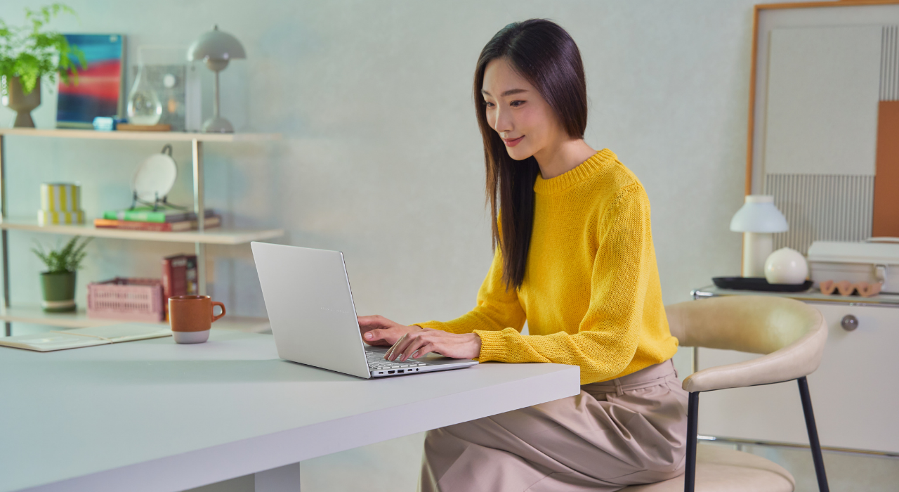 Freelancer sedang bekerja menggunakan ASUS Vivobook S14 laptop AI 2025 di ruang kerja modern